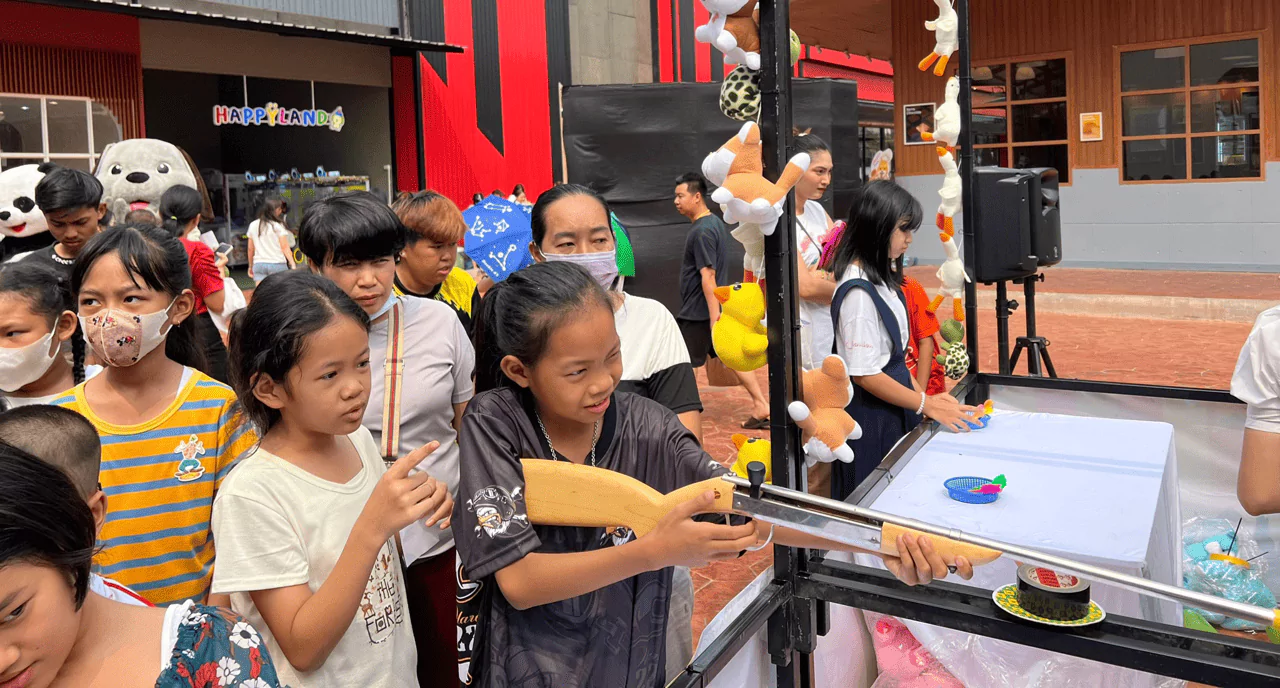 เด็กผู้หญิงและผู้ชายหลายคนกำลังเล่นกิจกรรมยิงปืน