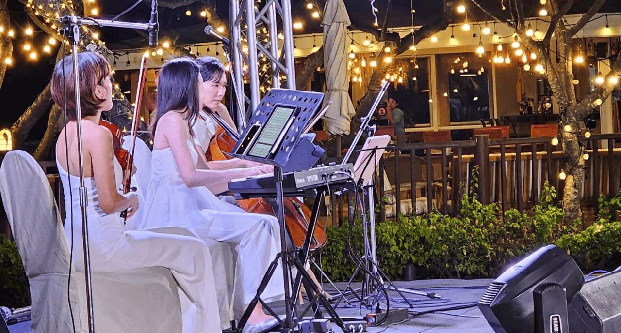 นักดนตรีสามคนกำลังเล่นดนตรีอยู่บนเวที