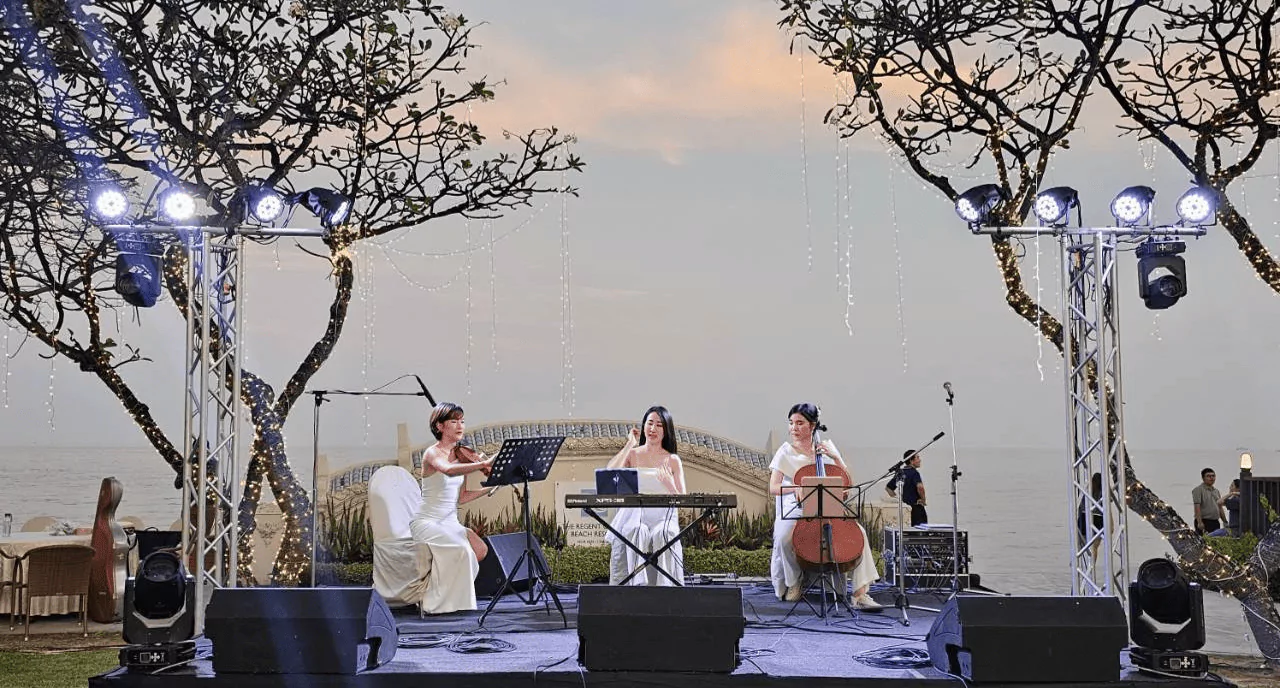 นักดนตรีสามคนกำลังเล่นดนตรีอยู่บนเวที