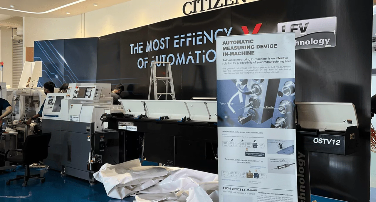 บูธเปิดตัวสินค้าสีดำขนาดใหญ่ มีบันไดอลูมิเนียมทรงเอกางอยู่ และป้ายรายละเอียดสินค้าอยู่ด้านหน้า