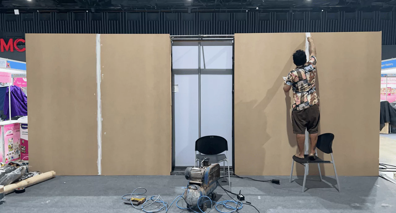 พนักงานกำลังติดตั้งบูธขายสินค้าเกี่ยวกับสัตว์เลี้ยงขนาดใหญ่