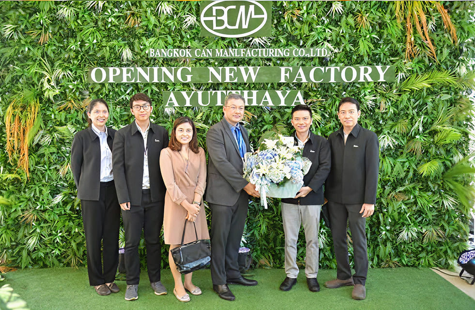 ผู้ชายและผู้หญิงแต่งกายแบบทางการกำลังถ่ายรูปที่หน้าแบคดรอป