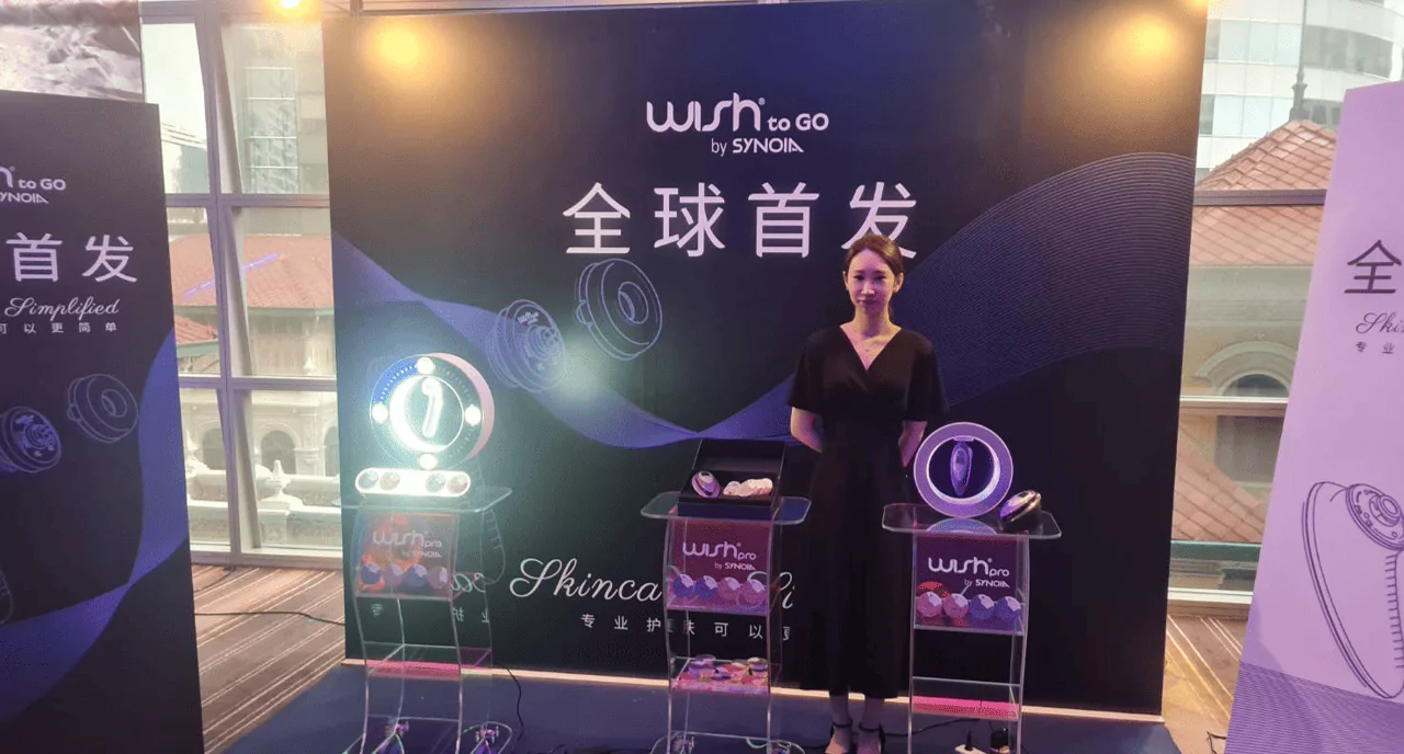 ผู้หญิงใส่ชุดสีดำกำลังถ่ายภาพกับแบคดรอปสีดำตกแต่งด้วยลูกโป่งสีน้ำเงินและ สีทอง